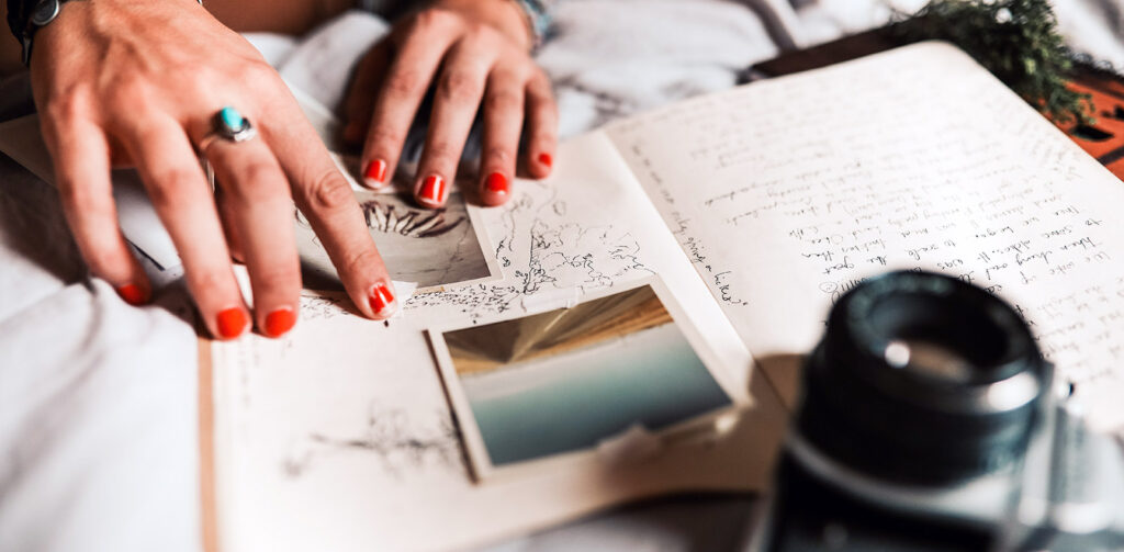 Closeup of someone's hands taping a photograph into a journal.